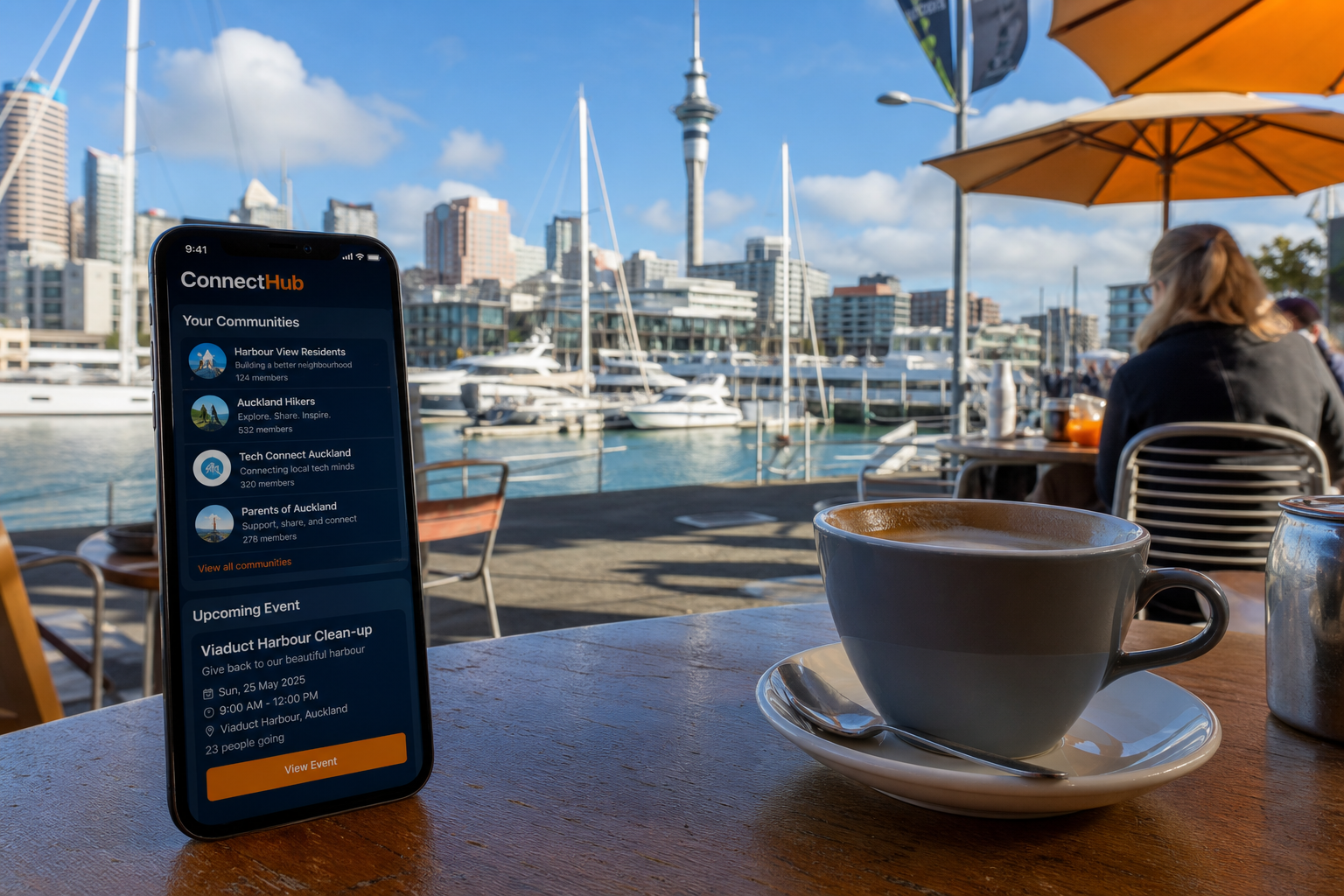 Sunny Auckland waterfront with a smartphone showing an original community group list and event